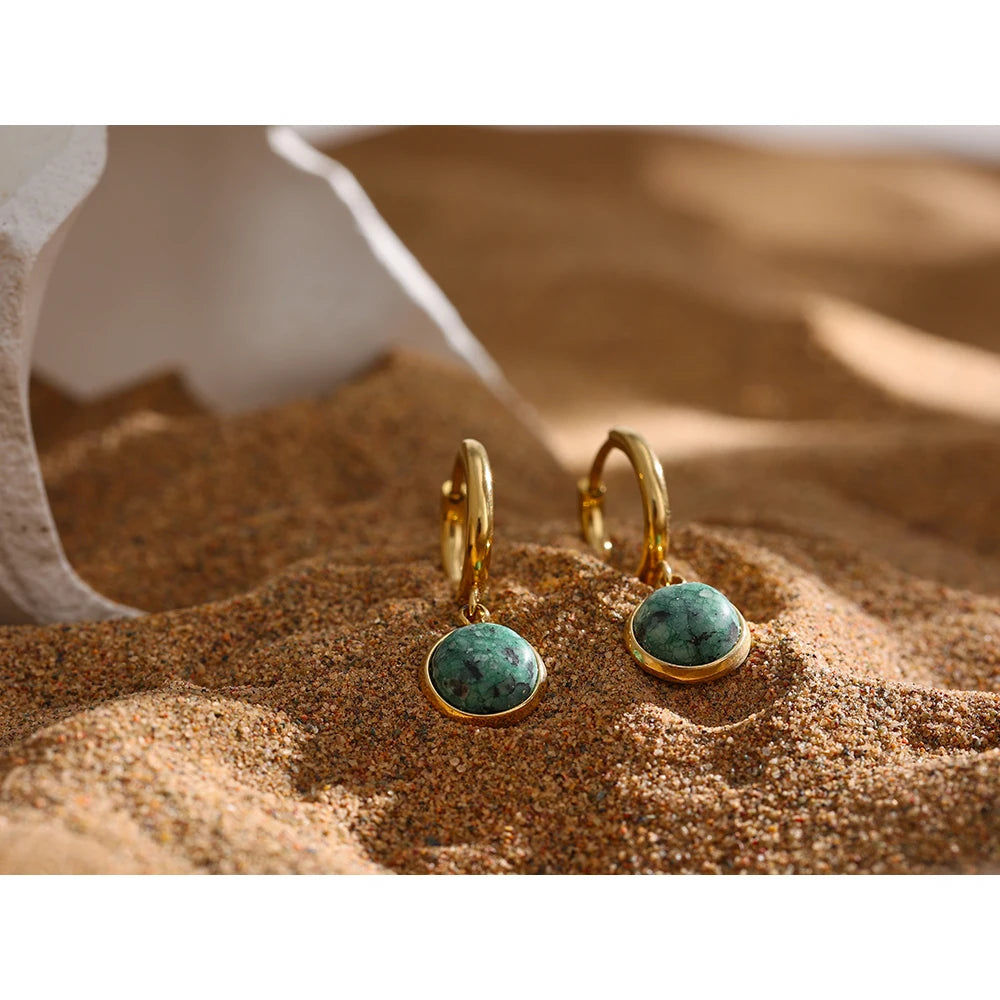 The Green Stone Charm Hoop Earrings exude majesty and elegance, reminiscent of the legendary stone of the African queen. Each green stone is delicately cut to enhance its natural beauty and vibrant hue, adding a touch of exoticism and sophistication to your look.