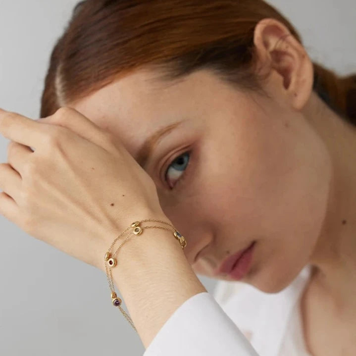 Model wearing the Rainbow Bracelet with Circular Zirconias, showcasing its burst of hues and vibrant rainbow-like appearance, made from sustainable stainless steel with 18k gold plating