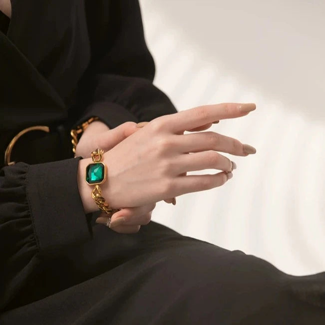 Model wearing the Emerald Chunky Chain Bracelet, showcasing its bold and modern design with a synthetic emerald, made from sustainable stainless steel with 18k gold plating