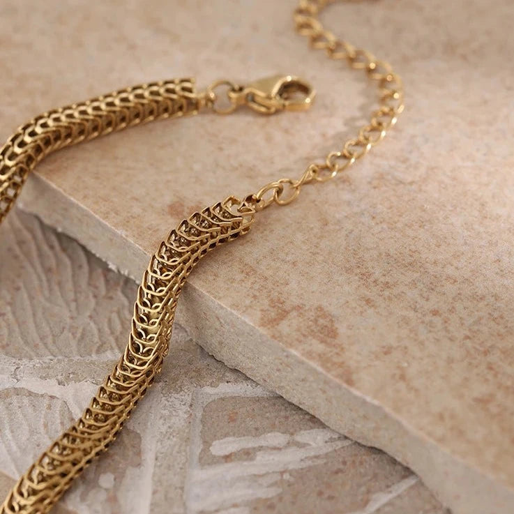 Introducing our Golden Scales Necklace - Mystical Elegance. Crafted from hypoallergenic stainless steel and plated with sustainable 18k gold. Inspired by dragon scales, featuring a captivating textured pattern. Versatile, adding glamour to any attire. Comfortable and enduring for daily wear.