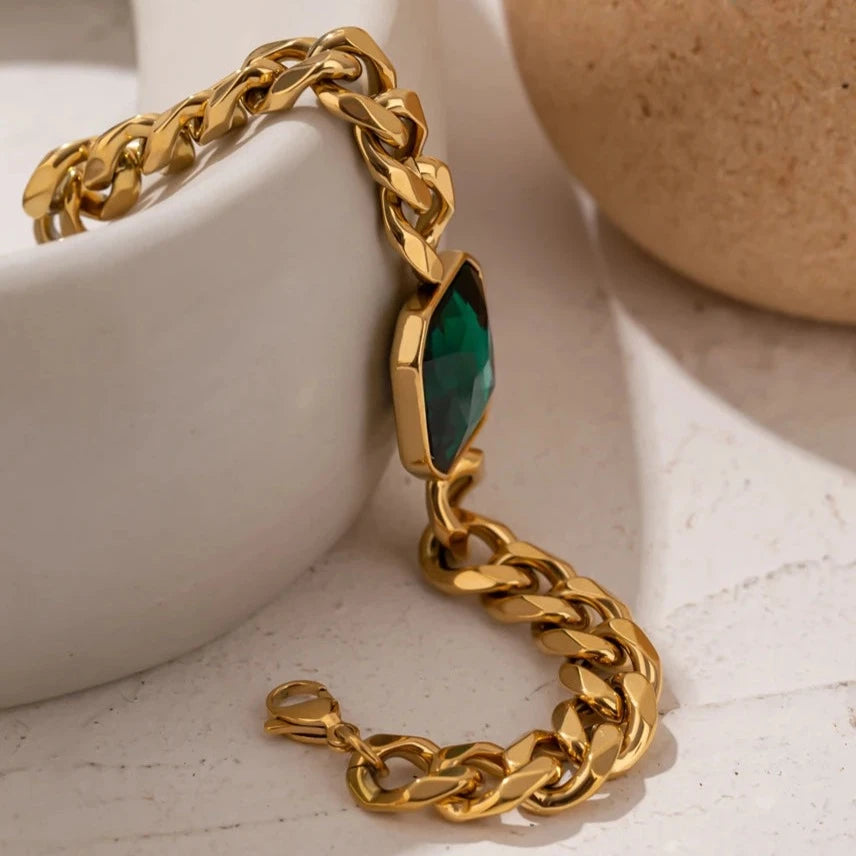 Close-up of the Emerald Chunky Chain Bracelet, highlighting the vibrant shine of the synthetic emerald and the sturdy gold-plated chain, crafted from hypoallergenic and sustainable materials