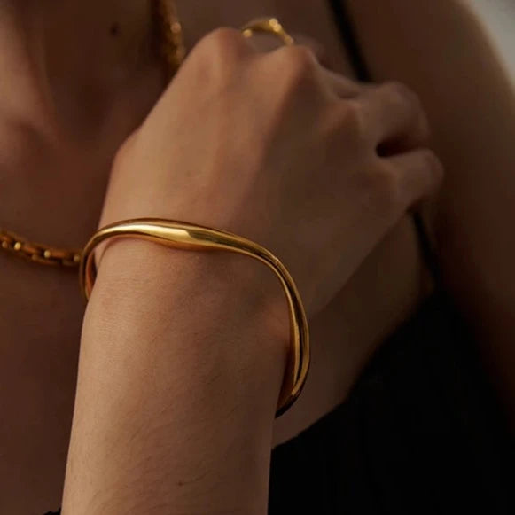 Minimalist Cuff Bracelet - Subtle Elegance. Crafted from hypoallergenic stainless steel, 18k gold plated, boasting a clean and sophisticated design. Versatile simplicity for enduring comfort and style.