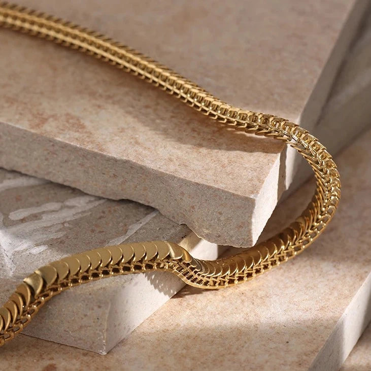 Introducing our Golden Scales Necklace - Mystical Elegance. Crafted from hypoallergenic stainless steel and plated with sustainable 18k gold. Inspired by dragon scales, featuring a captivating textured pattern. Versatile, adding glamour to any attire. Comfortable and enduring for daily wear.