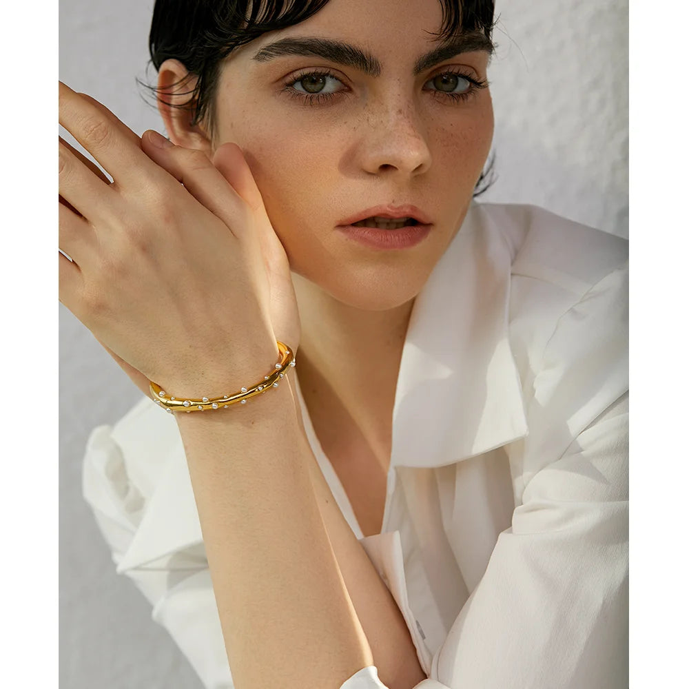 Elegant Pearl-Studded Cuff Bracelet - Timeless Sophistication. Crafted from hypoallergenic stainless steel, 18k gold plated, adorned with classic simulated pearls. Modern cuff design for enduring comfort and style.