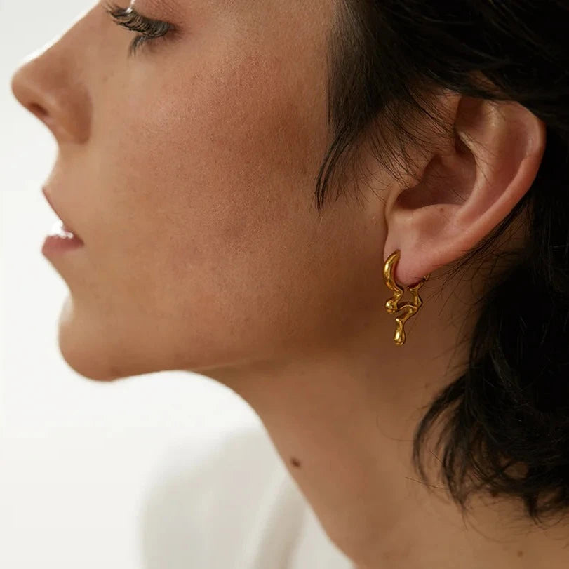 The Cascade earrings feature an elegant cascading design inspired by flowing water, crafted from hypoallergenic, eco-friendly stainless steel with a durable 18k gold plating. Perfect for a sophisticated and sustainable lifestyle.