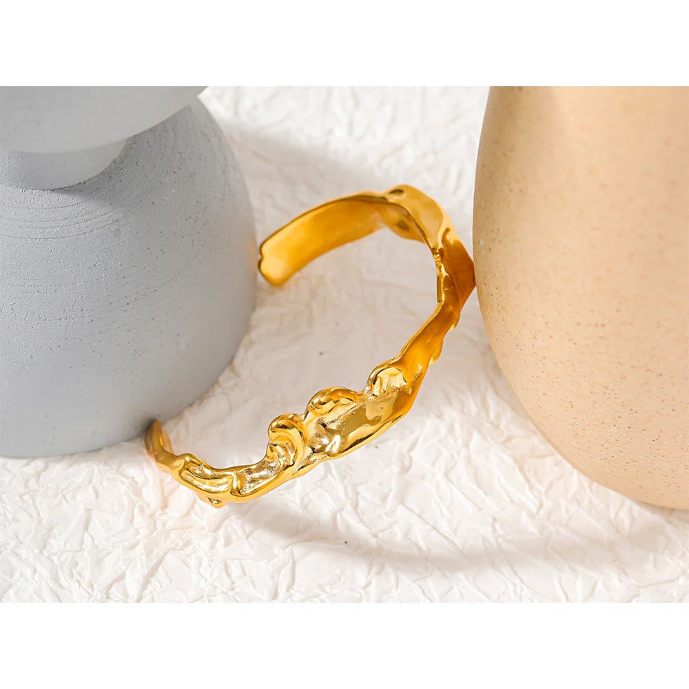 Flowing Gold Cuff Bracelet - Radiant Elegance. Crafted from hypoallergenic stainless steel, plated with enduring 18k gold. Adorned with dazzling cubic zirconias for added brilliance. Versatile and luxurious, designed for lasting comfort and style.