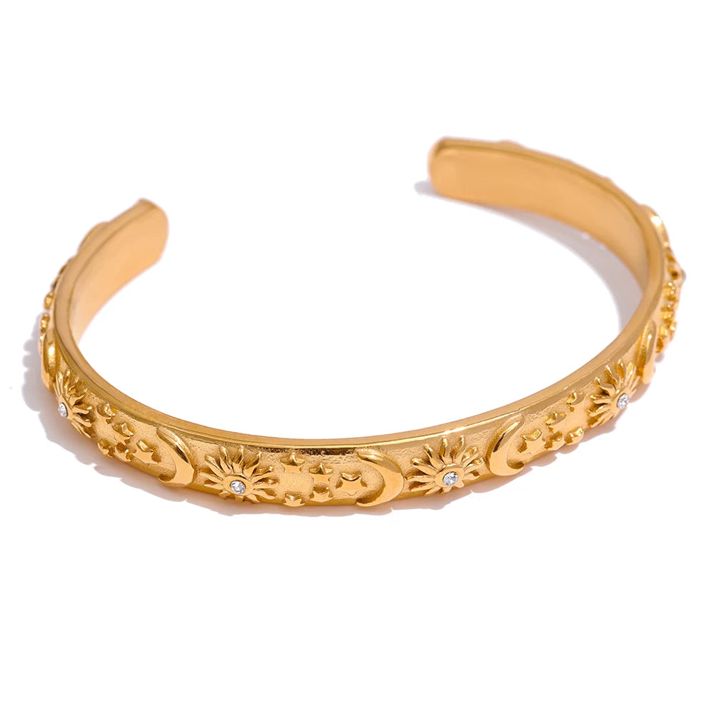 Celestial Cuff Bracelet - Cosmic Elegance. Crafted from hypoallergenic stainless steel, finished with durable 18k gold plating. Adorned with celestial designs symbolizing the sun, moon, and stars. Versatile and charming, designed for enduring comfort and style.