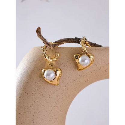 The Twisted Heart Hoop earrings blend classic twisted hoops with the delicate romance of hearts and timeless elegance of pearls. Crafted from hypoallergenic stainless steel and coated with durable 18k gold, these earrings are sustainable, durable, and perfect for daily wear or special occasions, adding elegance and romance to any look.