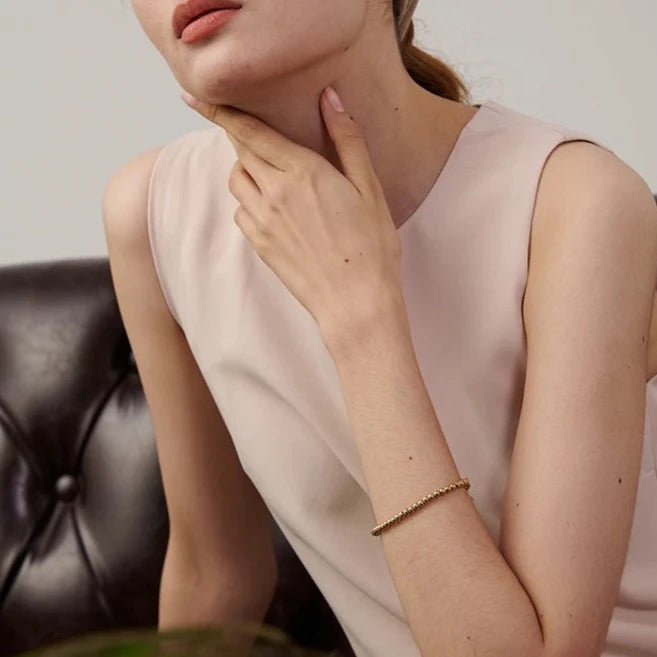 Model wearing the Golden Balls Chain Bracelet, showcasing its luxurious design and dazzling shine from the certified moissanite, made from sustainable stainless steel with 18k gold plating