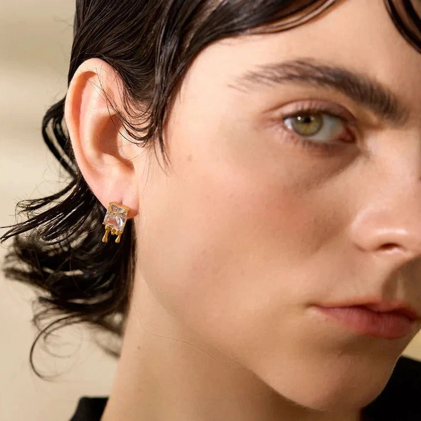 Elegant model showcasing the Flowing Gold Earrings, demonstrating their versatility and lasting comfort, featuring a unique fluid design and sparkling cubic zirconias.