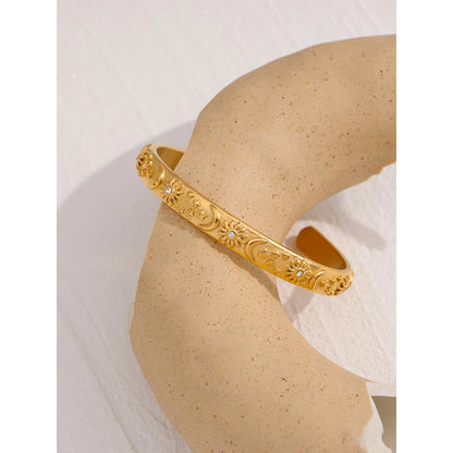 Celestial Cuff Bracelet - Cosmic Elegance. Crafted from hypoallergenic stainless steel, finished with durable 18k gold plating. Adorned with celestial designs symbolizing the sun, moon, and stars. Versatile and charming, designed for enduring comfort and style.