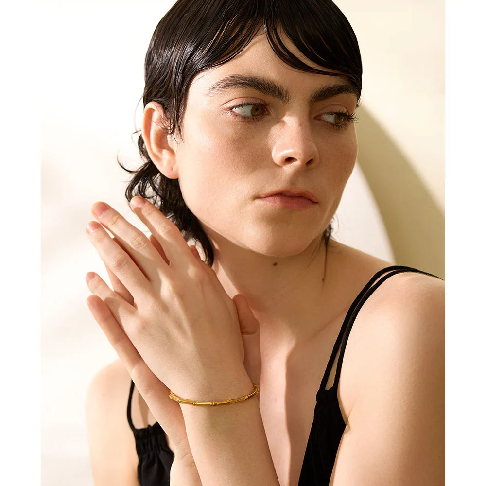 Elevate your style with our Golden Bamboo Cuff Bracelet, inspired by the elegance of bamboo. Crafted from hypoallergenic stainless steel with a sustainable 18k gold plating, its organic design adds natural sophistication to any ensemble.