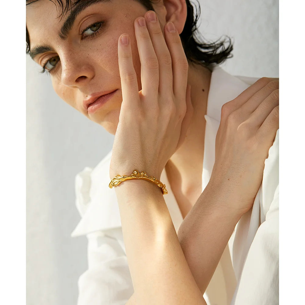 Flowing Gold Cuff Bracelet - Radiant Elegance. Crafted from hypoallergenic stainless steel, plated with enduring 18k gold. Adorned with dazzling cubic zirconias for added brilliance. Versatile and luxurious, designed for lasting comfort and style.