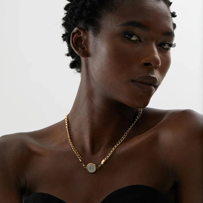 Introducing our African Coin Pendant Necklace - Celebrating Heritage. Crafted from hypoallergenic stainless steel and plated with sustainable 18k gold. Features an elegant African coin pendant on a sleek chain. Seamlessly blends tradition with contemporary style. Versatile for any occasion. Eco-conscious and enduring.