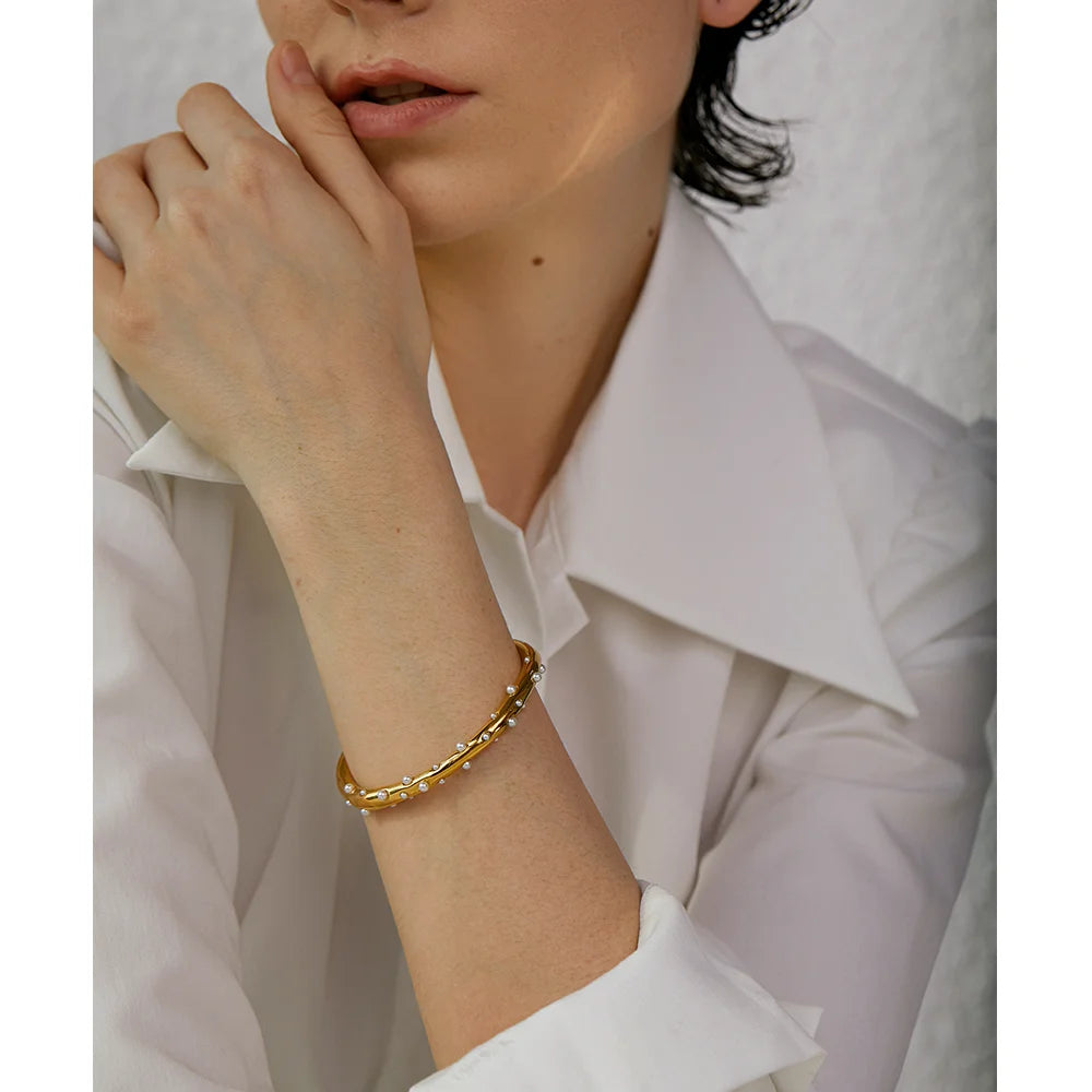 Elegant Pearl-Studded Cuff Bracelet - Timeless Sophistication. Crafted from hypoallergenic stainless steel, 18k gold plated, adorned with classic simulated pearls. Modern cuff design for enduring comfort and style.