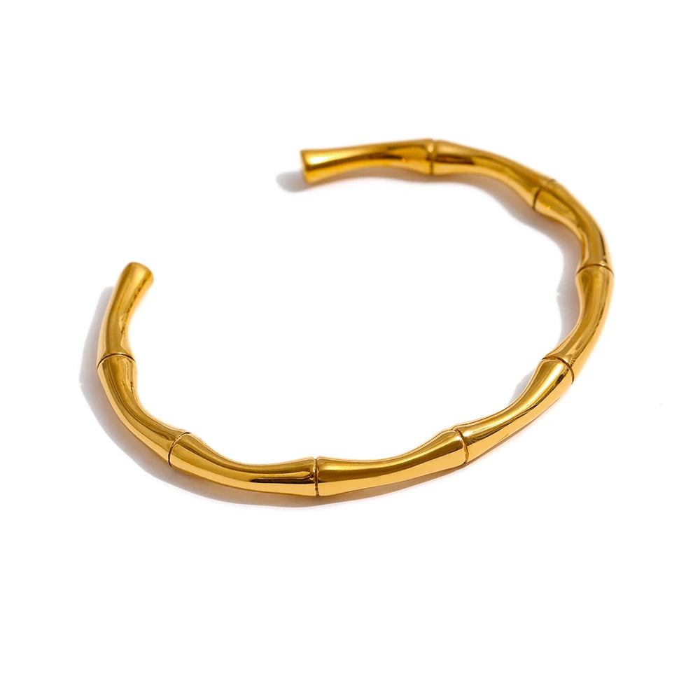 Elevate your style with our Golden Bamboo Cuff Bracelet, inspired by the elegance of bamboo. Crafted from hypoallergenic stainless steel with a sustainable 18k gold plating, its organic design adds natural sophistication to any ensemble.