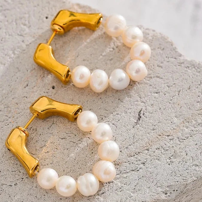 These exquisite earrings showcase a row of natural freshwater pearls, each selected for its exceptional quality, smooth iridescence, and luminous glow. Crafted from hypoallergenic stainless steel and plated with durable 18k gold, they embody elegance and luxury in every detail, reflecting light beautifully. Ideal for those seeking sophistication with a sustainable touch.