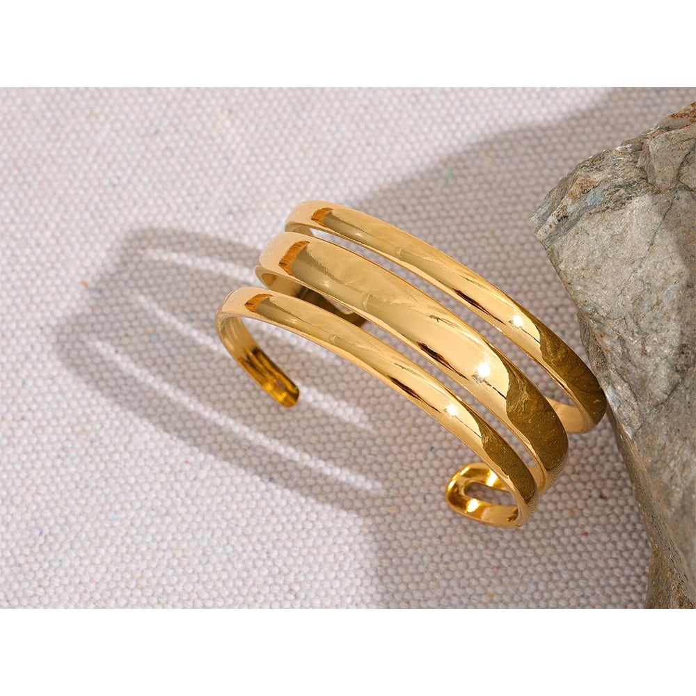 Triple Cuff Bracelet - Contemporary Sophistication. Crafted from hypoallergenic stainless steel with sustainable 18k gold plating. Versatile triple-sectioned design for elegant allure. Comfortable and enduring for all occasions.