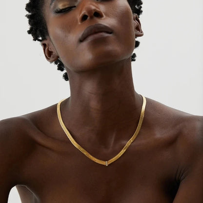 Stylish model showcasing the Basic Cuban Necklace, demonstrating its wide Cuban chain design and superior durability, made from sustainable materials and plated with 18k gold.