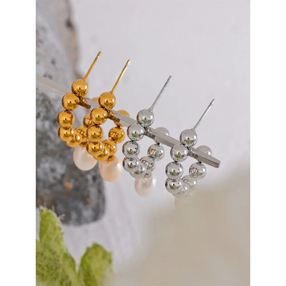 The Mini Sphere Hoop earrings with Pearl Dangle feature a charming contemporary design with small sphere hoops and delicate simulated pearls. Crafted from hypoallergenic, eco-friendly stainless steel with a durable 18k gold plating, they offer durability and sustainability for an elegant, conscious lifestyle.