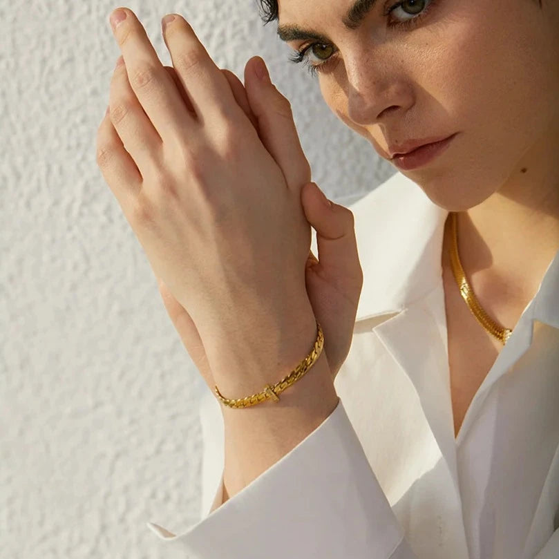 Model wearing Basic Cuban Bracelet, highlighting its timeless design and dazzling brilliance of the cubic zirconias, made from sustainable stainless steel with 18k gold plating.