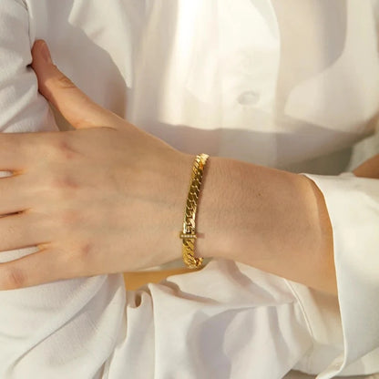 Elegant model wearing the Basic Cuban Bracelet, emphasizing its lasting comfort and waterproof design, crafted from hypoallergenic stainless steel and plated with 18k gold.