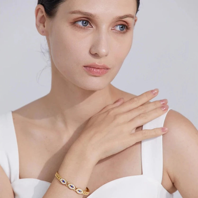 Model wearing the Triple Greek Eye Protection Bracelet, showcasing its elegant design and spiritual protection with three Greek eyes and cubic zirconias, made from sustainable stainless steel with 18k gold plating