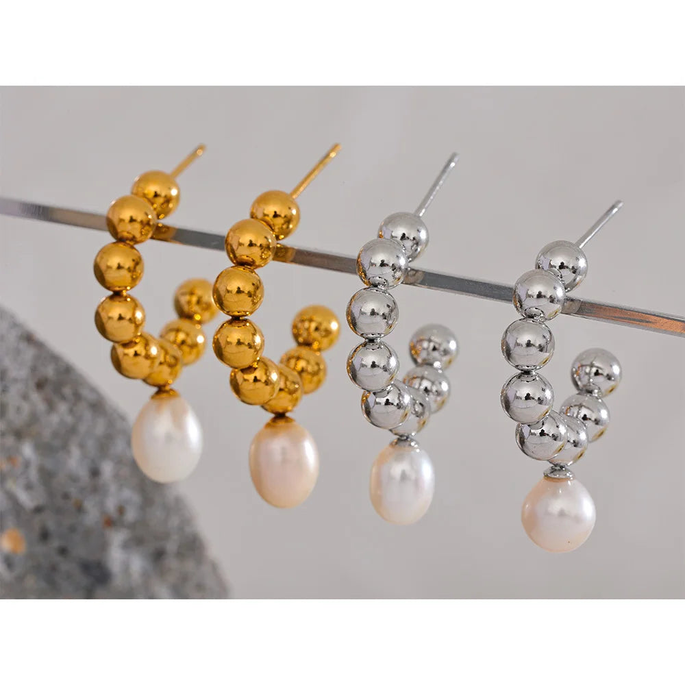 The Mini Sphere Hoop earrings with Pearl Dangle feature a charming contemporary design with small sphere hoops and delicate simulated pearls. Crafted from hypoallergenic, eco-friendly stainless steel with a durable 18k gold plating, they offer durability and sustainability for an elegant, conscious lifestyle.