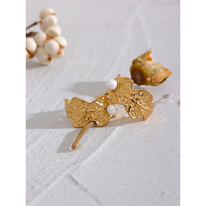 The Egyptian Leaf Pearl earrings blend ancient Egyptian artistry with contemporary elegance. Adorned with a simulated pearl, they're crafted from hypoallergenic stainless steel with a durable 18k gold plating, perfect for an elegant and conscious style.