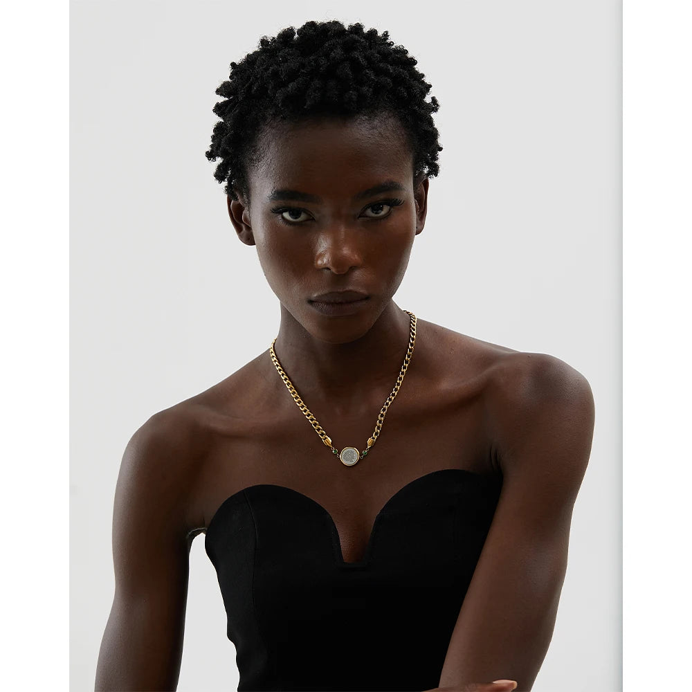 Introducing our African Coin Pendant Necklace - Celebrating Heritage. Crafted from hypoallergenic stainless steel and plated with sustainable 18k gold. Features an elegant African coin pendant on a sleek chain. Seamlessly blends tradition with contemporary style. Versatile for any occasion. Eco-conscious and enduring.