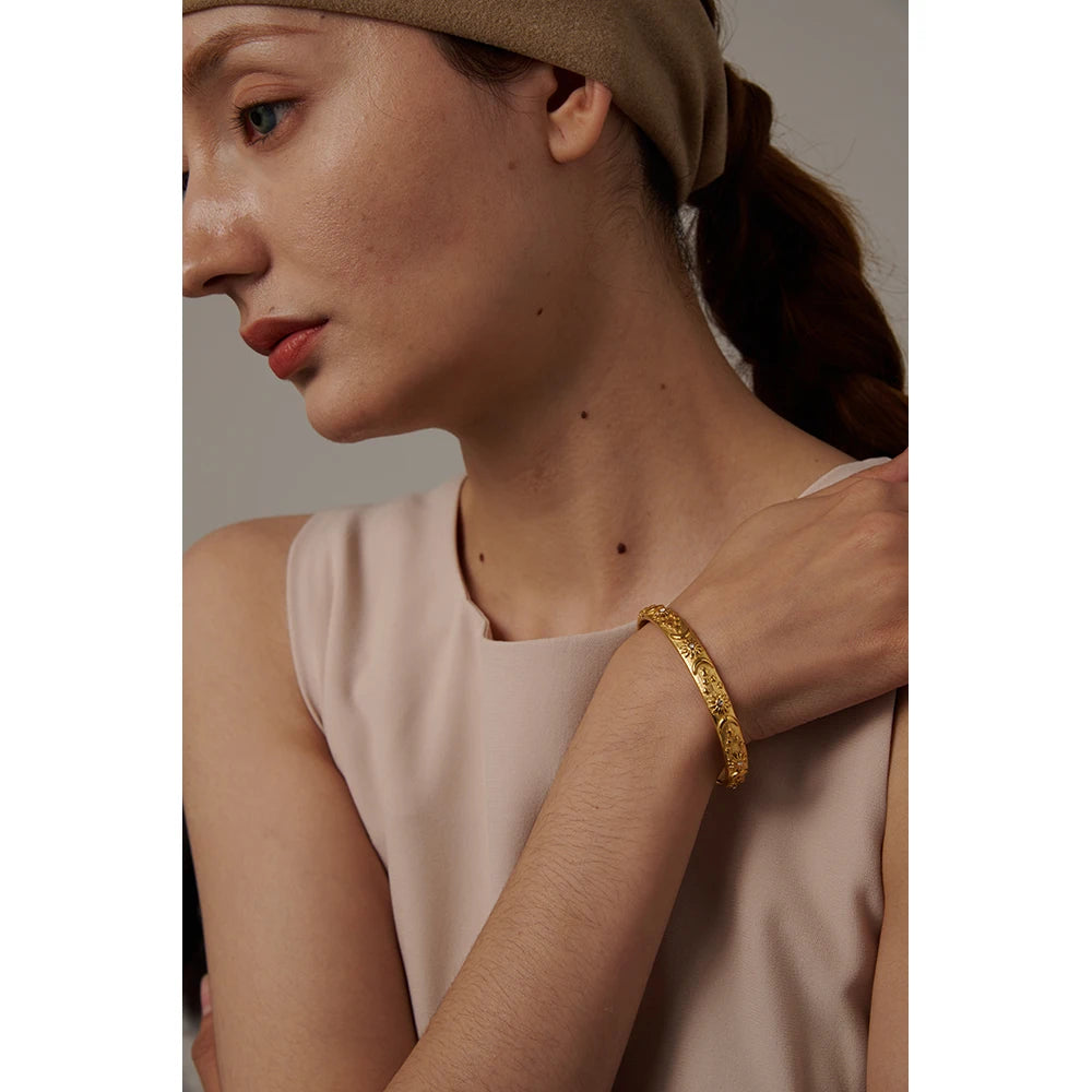 Celestial Cuff Bracelet - Cosmic Elegance. Crafted from hypoallergenic stainless steel, finished with durable 18k gold plating. Adorned with celestial designs symbolizing the sun, moon, and stars. Versatile and charming, designed for enduring comfort and style.